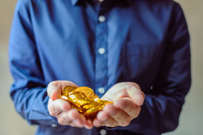Person holding gold coins ready to sell
