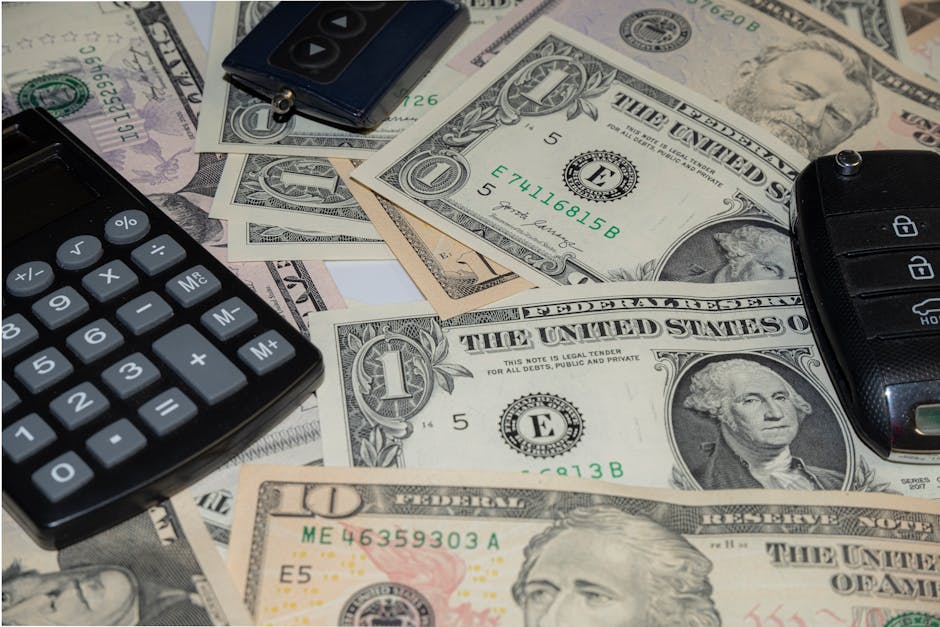 Car key beside cash and a calculator