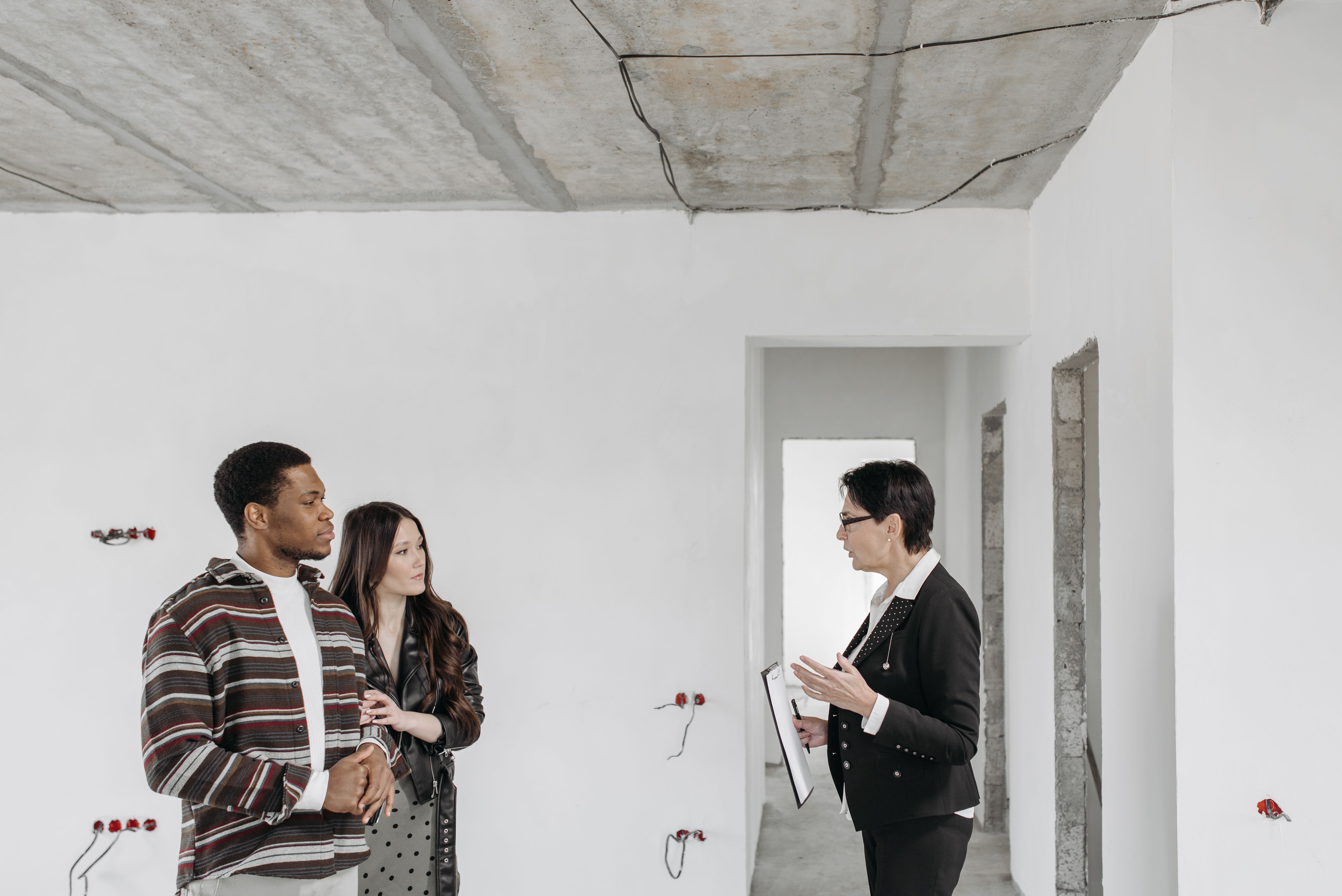 Real estate paperwork discussion inside an unfinished home