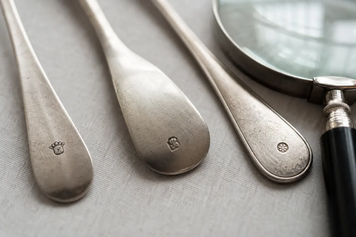 Close view of maker marks on vintage silverware