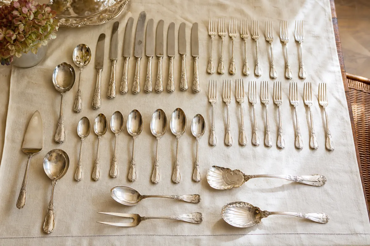 Complete silver-plated flatware set sorted on linen