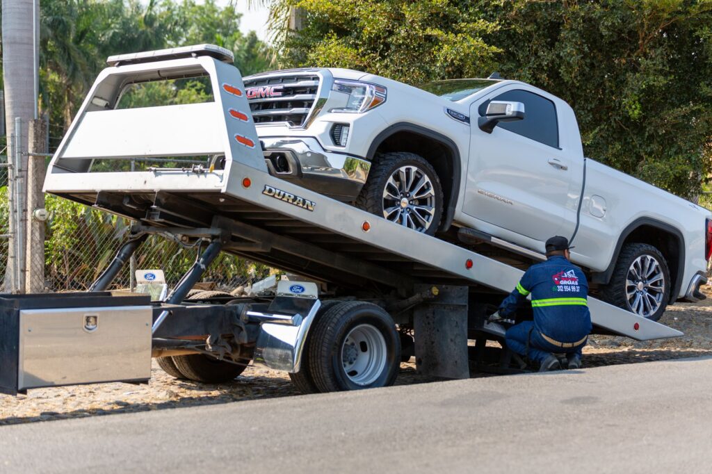 tow truck loading an older vehicle for a junk car cash offer