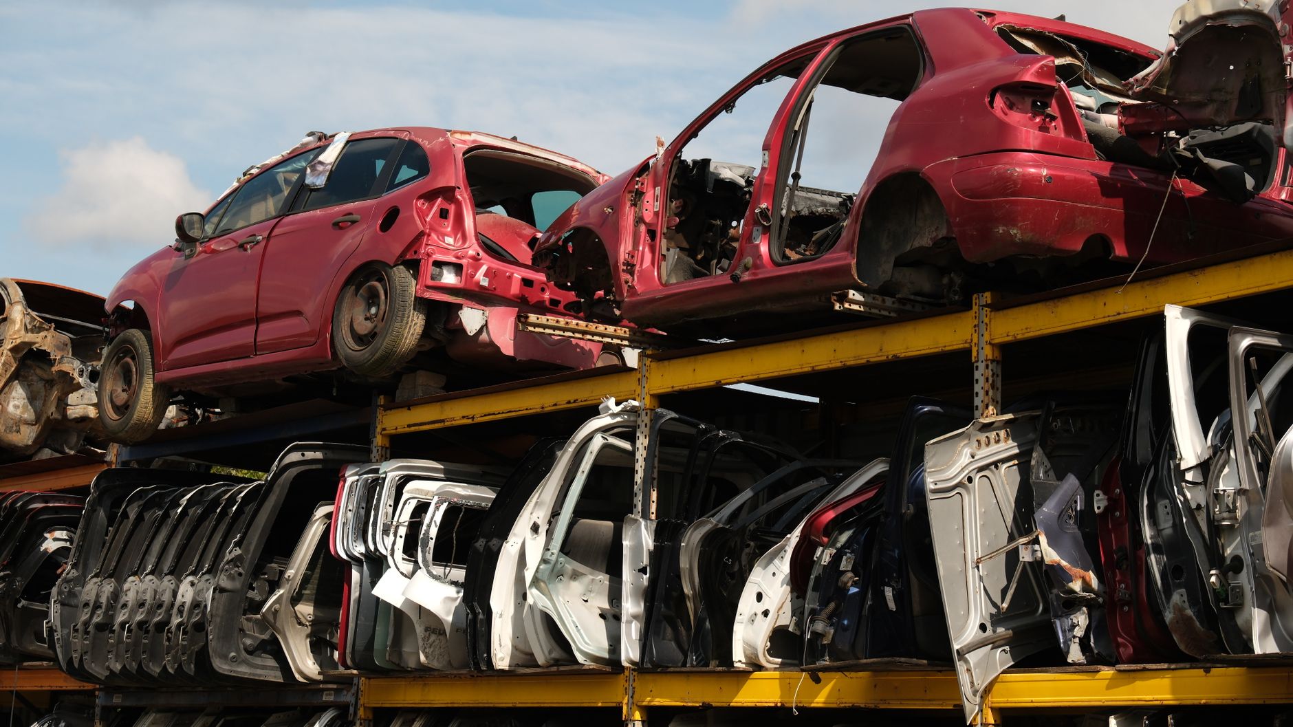 stacked car shells in a salvage yard for parts value