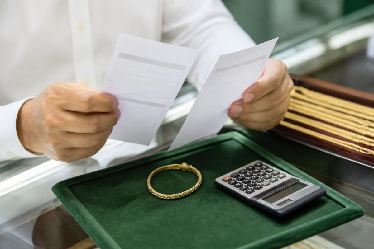 Consumer comparing gold purchase offers at a jewelry counter